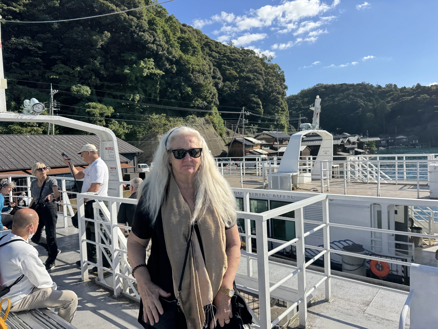 Anneliese at the boat landing, with wooded hills behind her